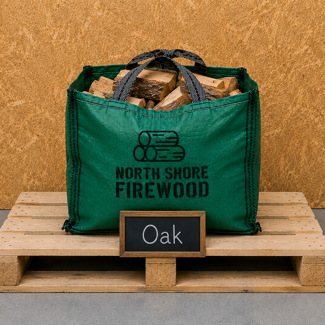 Green bag of firewood labeled 'North Shore Firewood' on a wooden pallet with a 'Oak' sign.