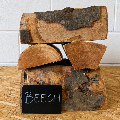 Stack of firewood with a 'BEECH' label on a wooden surface.