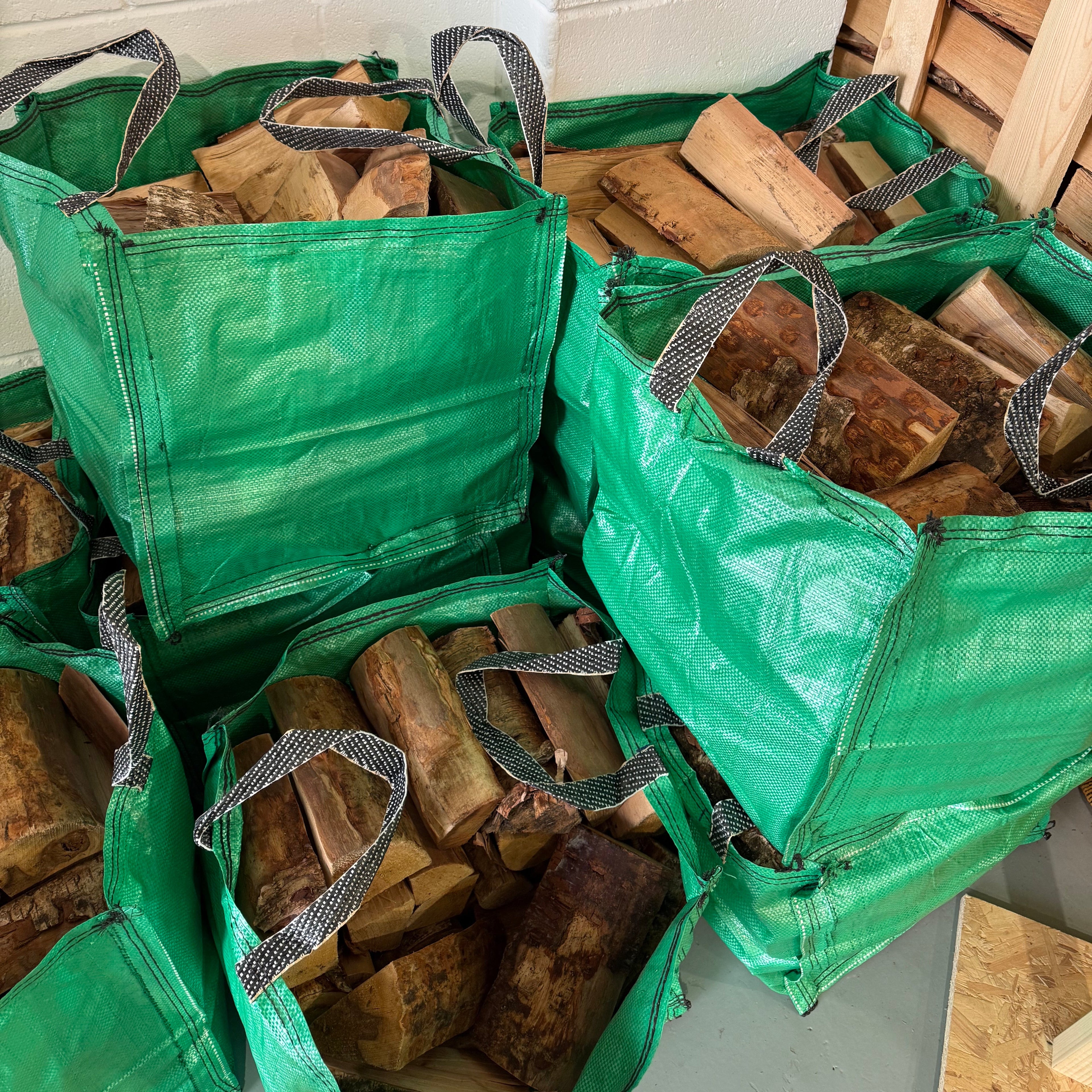 Green bags filled with Birch firewood.