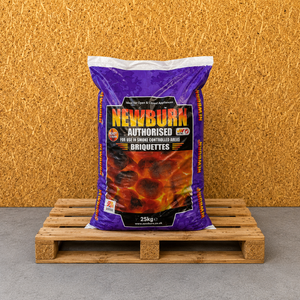 Bag of Newburn briquettes on a wooden pallet with a textured brown wall background