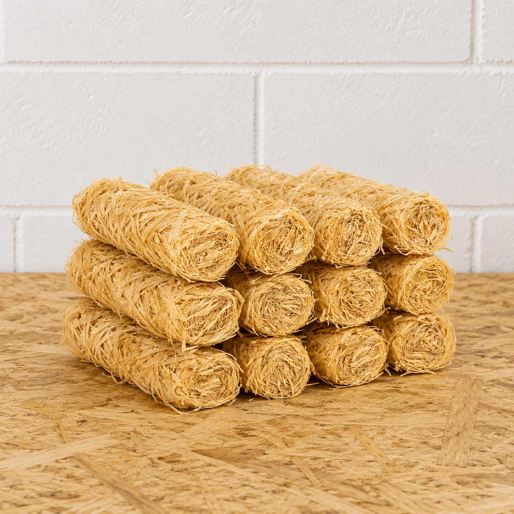 Stack of yellow rolled towels on a wooden surface with a white tiled wall background
