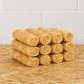 Stack of yellow rolled towels on a wooden surface with a white tiled wall background